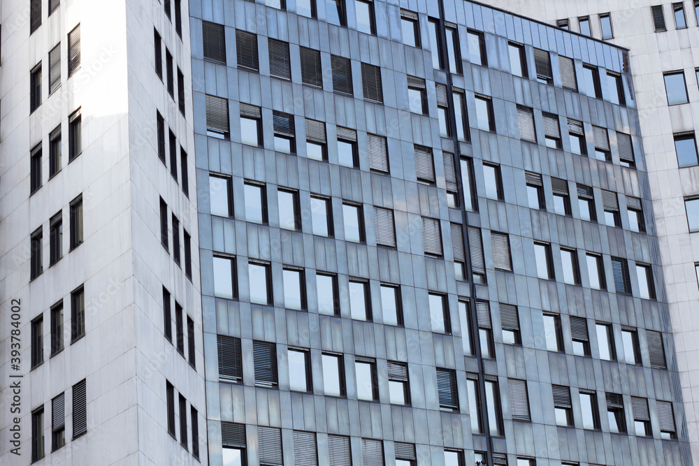 Abstract view of a skyscraper. Exterior of a glass office building with symmetrical lines and light gray colors. Abstract view of a skyscraper. Exterior of a glass office building with symmetrical lines and light gray colors.