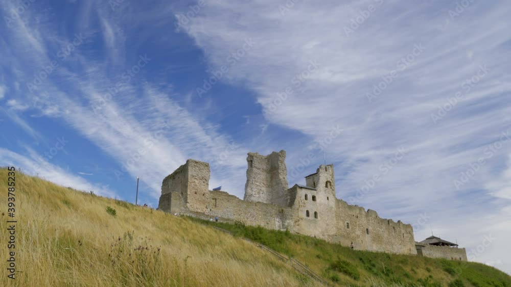 The grasses on the hill with the big castle on the top with the blue sky above in Estonia The grasses on the hill with the big castle on the top with the blue sky above in Estonia