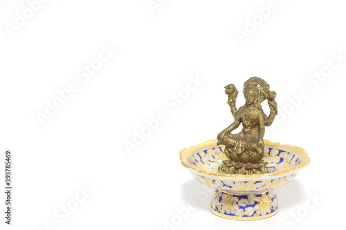 Brass figure of the Hindu goddess Lakshmi on white background.