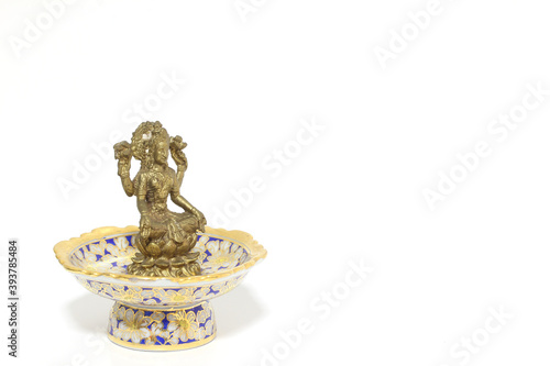 Brass figure of the Hindu goddess Lakshmi on white background.