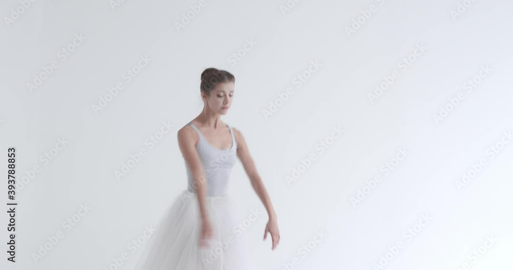 Dramatic dance, elegant female in a white tutu, dance ballet and perform choreographic elements on a white background, rehearsal. Dramatic dance, elegant female in a white tutu, dance ballet and perform choreographic elements on a white background, rehearsal.