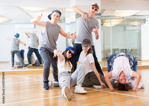 Portrait of cheerful teenage girls and boys hip hop dancers posing during group dance workout