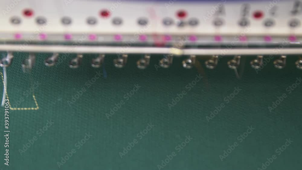 Machine embroiders letters of logo on hockey team uniform Machine embroiders letters of logo on hockey team uniform