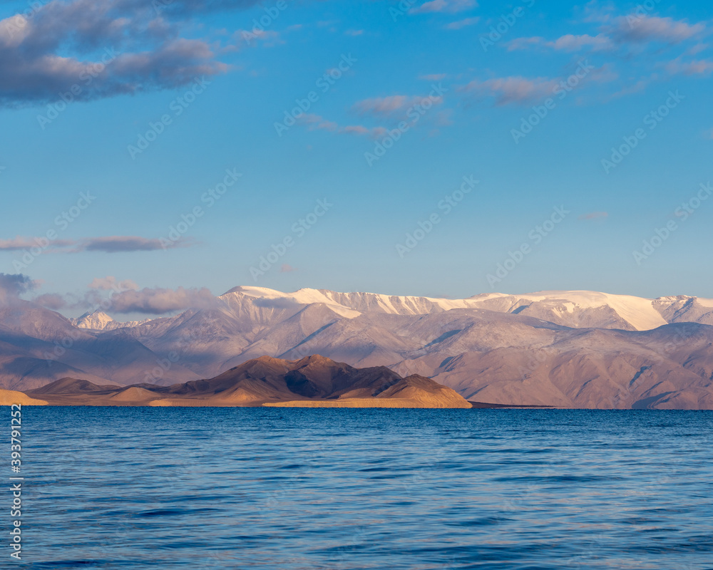 View from the shores of Karakul lake at sunrise, with Zulumart snow-capped mountain range in the background, Murghab district, Gorno-Badakshan, in the Pamir region of Tajikistan