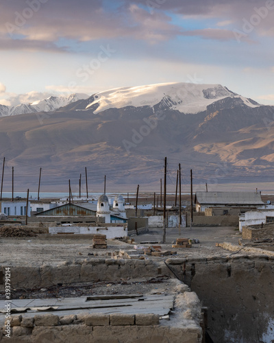 Karakul village on the shores of Karakul lake, at sunset with snow-capped mountain background, Murghab district, in the Gorno-Badakshan Pamir region of Tajikistan photo