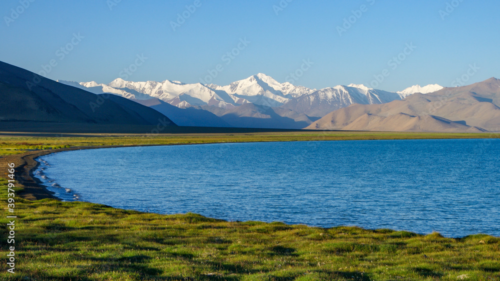 View from the shores of Karakul lake at sunrise, with Muskol snow-capped mountain range in the background, Murghab district, Gorno-Badakshan, in the Pamir region of Tajikistan