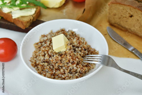 Buckwheat porridge with butter.Bowl of tasty buckwheat porridge on wooden table.Healthy breakfast for schoolchildren.