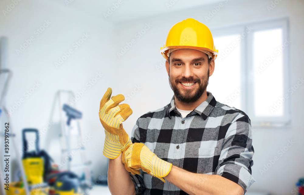 repair, construction and work concept - happy smiling male worker or builder in helmet and gloves over room with building equipment background repair, construction and work concept - happy smiling male worker or builder in helmet and gloves over room with building equipment background