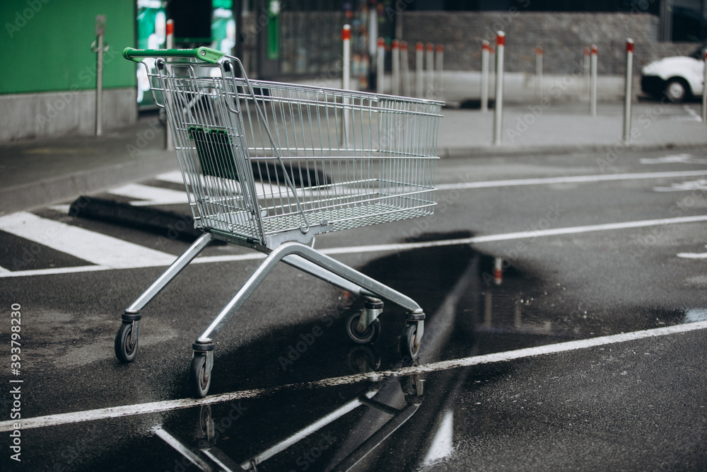 a supermarket basket is on the asvalt and a puddle of water, a wheelchair a supermarket basket is on the asvalt and a puddle of water, a wheelchair