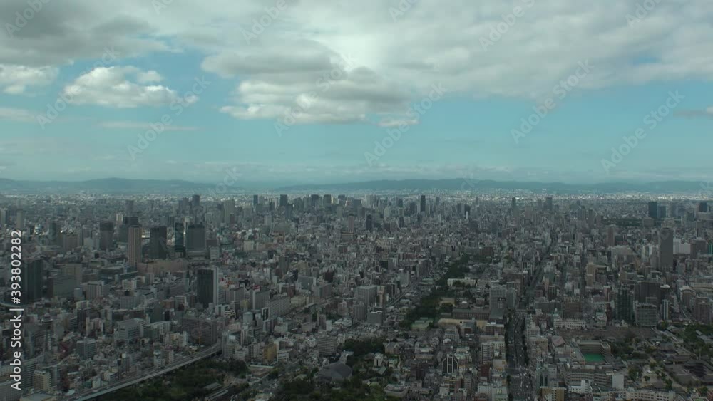 OSAKA, JAPAN : Aerial high angle view of CITYSCAPE of OSAKA in day time. View of buildings and streets around Namba, Shinsaibashi, Umeda and Osaka train station. Wide view time lapse tracking shot. OSAKA, JAPAN : Aerial high angle view of CITYSCAPE of OSAKA in day time. View of buildings and streets around Namba, Shinsaibashi, Umeda and Osaka train station. Wide view time lapse tracking shot.