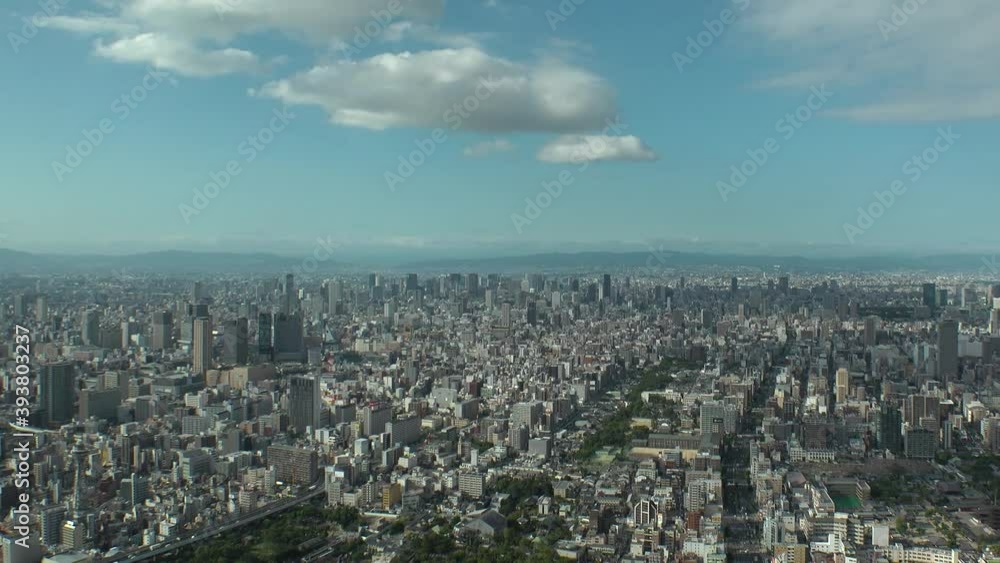 OSAKA, JAPAN : Aerial high angle view of CITYSCAPE of OSAKA in day time. View of buildings and streets around Namba, Shinsaibashi, Umeda and Osaka train station. Wide view time lapse tracking shot. OSAKA, JAPAN : Aerial high angle view of CITYSCAPE of OSAKA in day time. View of buildings and streets around Namba, Shinsaibashi, Umeda and Osaka train station. Wide view time lapse tracking shot.