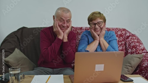 An senior couple are surprised to see their grandson via video communication. photo