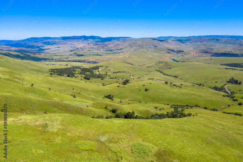 Aerial panoramic view of rugged mountain range on a clear day, with mountain plateau in the background.
