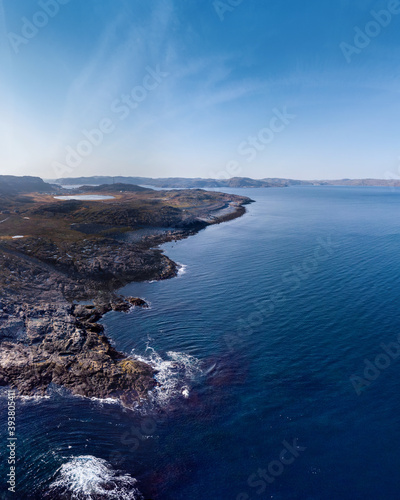 Top view aerial photo from flying drone of an amazingly beautiful sea landscape, blue water, rocky coast line. Barents Sea. Autumn in tundra, bright sunny day, vivid colors 