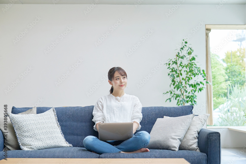 リビングでパソコンを使う女性 リビングでパソコンを使う女性