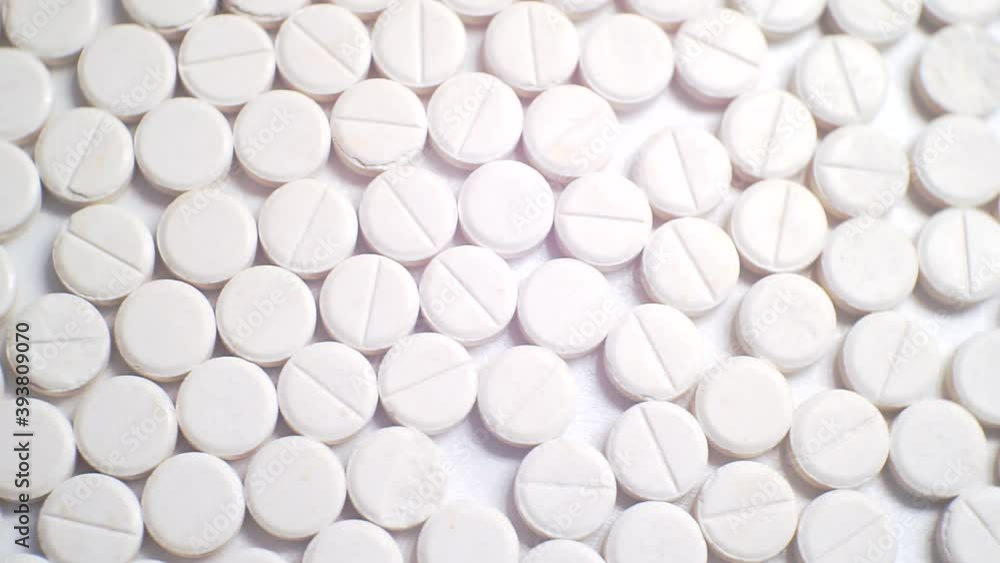 many white round pills. pharmaceutical production. close-up. many white round pills. pharmaceutical production. close-up.