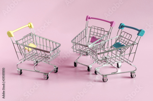empty metal carts from the store on a colored background place under the text trade concept 
