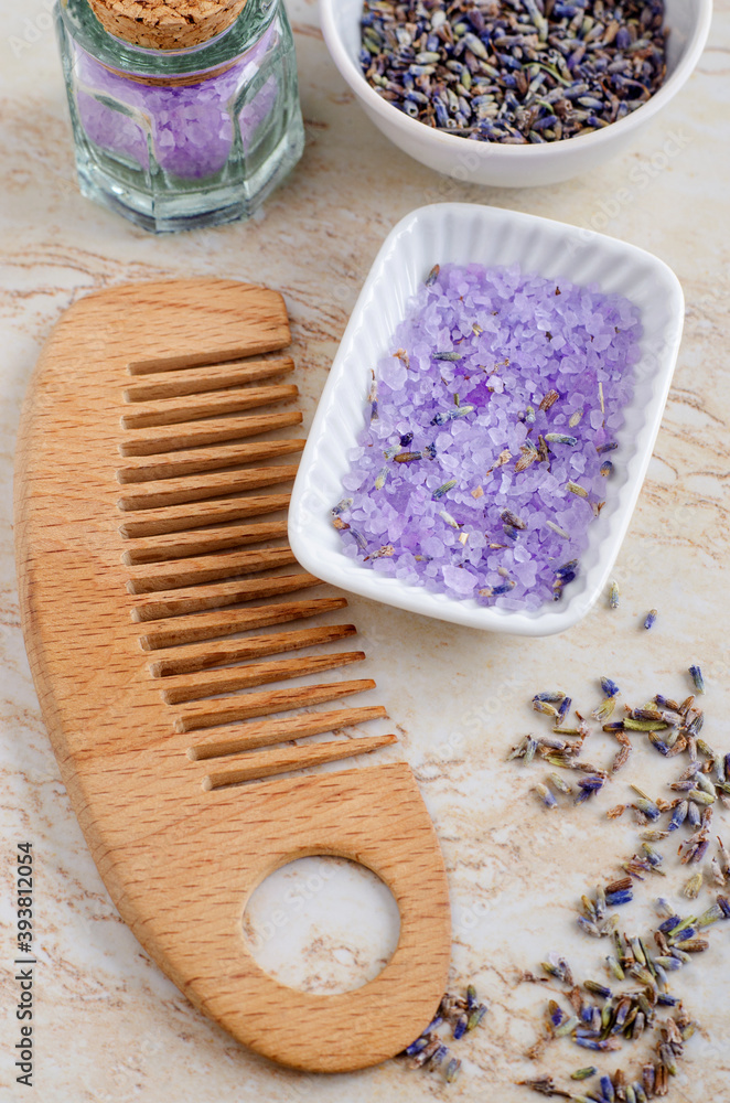 Small porcelain bowl with purple bath salts (foot soak), dry lavender flowers and wooden hair brush. Homemade spa and beauty recipe. Small porcelain bowl with purple bath salts (foot soak), dry lavender flowers and wooden hair brush. Homemade spa and beauty recipe.