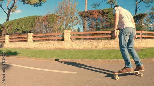 Labrador retriever breed dog runs behind his owner who is skating through the urbanization on a sunny morning