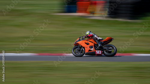 A panning shot of a racing bike cornering on a track.