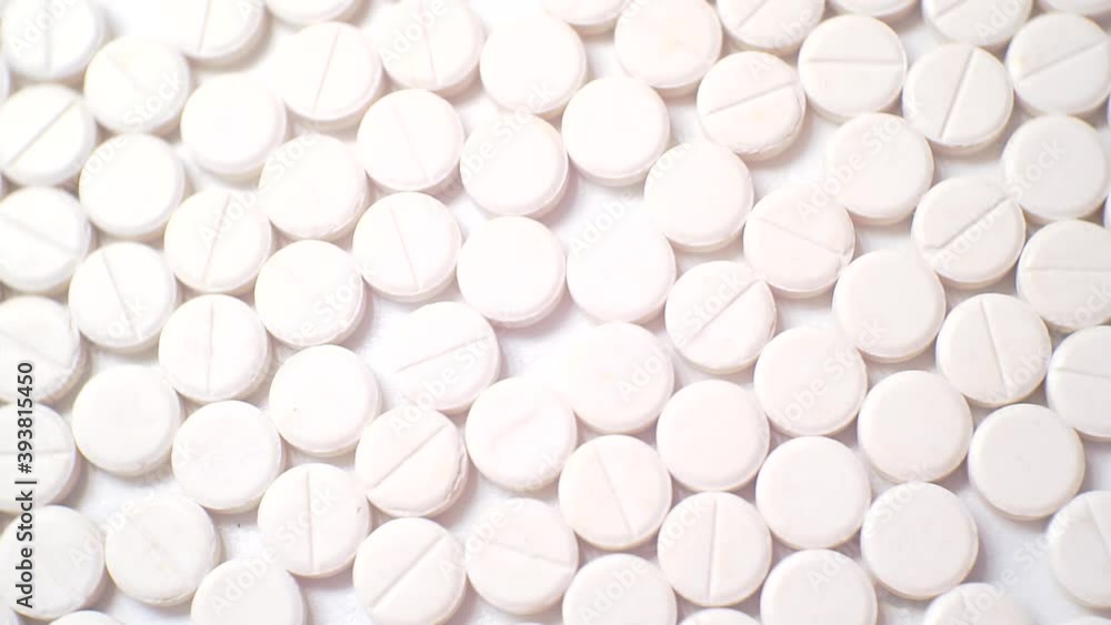 many white round pills. pharmaceutical production. close-up. many white round pills. pharmaceutical production. close-up.
