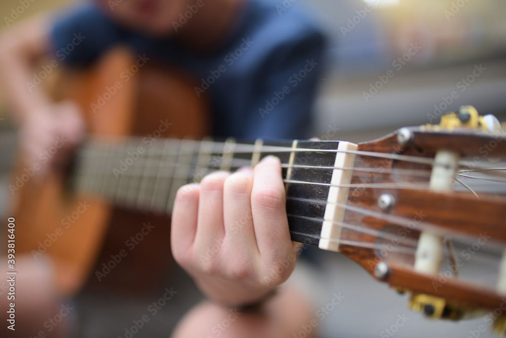 Young boy playing guitar outdoors
