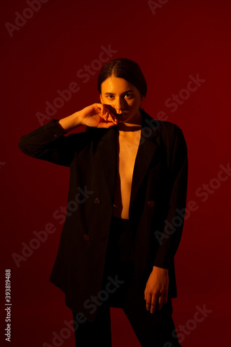 Girl in a black jacket on a red background