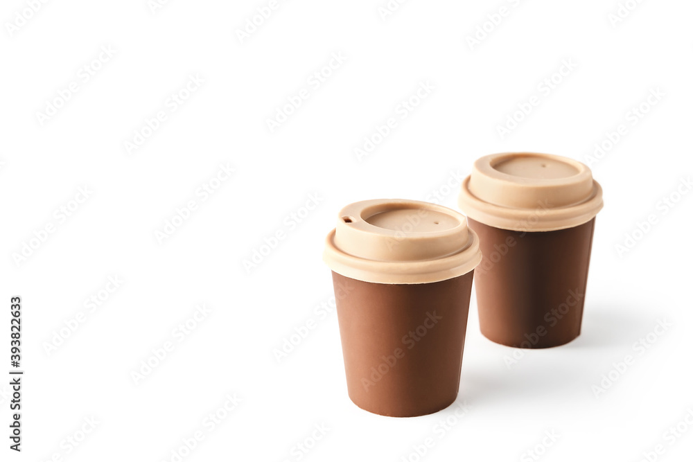 Two beautiful takeaway cups made of chocolate on isolated white background. Abstract design template on white backdrop. Food and drink concept. Coffee background. Copy space. Two beautiful takeaway cups made of chocolate on isolated white background. Abstract design template on white backdrop. Food and drink concept. Coffee background. Copy space.