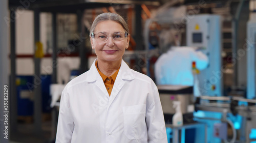 Wallpaper Mural Mature woman scientist in protective glasses and lab coat standing at chemical manufacturing Torontodigital.ca