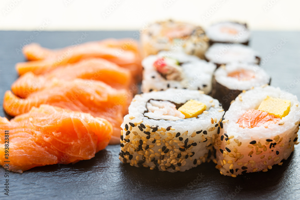 Sushi, uramaki, rolls and sashimi on a slate tray. Sushi, uramaki, rolls and sashimi on a slate tray.