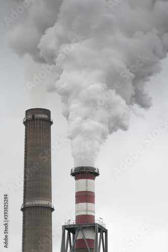 Smoking pipes of thermal power plant with dramatic dark cloudy sky