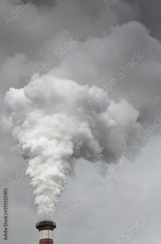 Smoking pipes of thermal power plant with dramatic dark cloudy sky