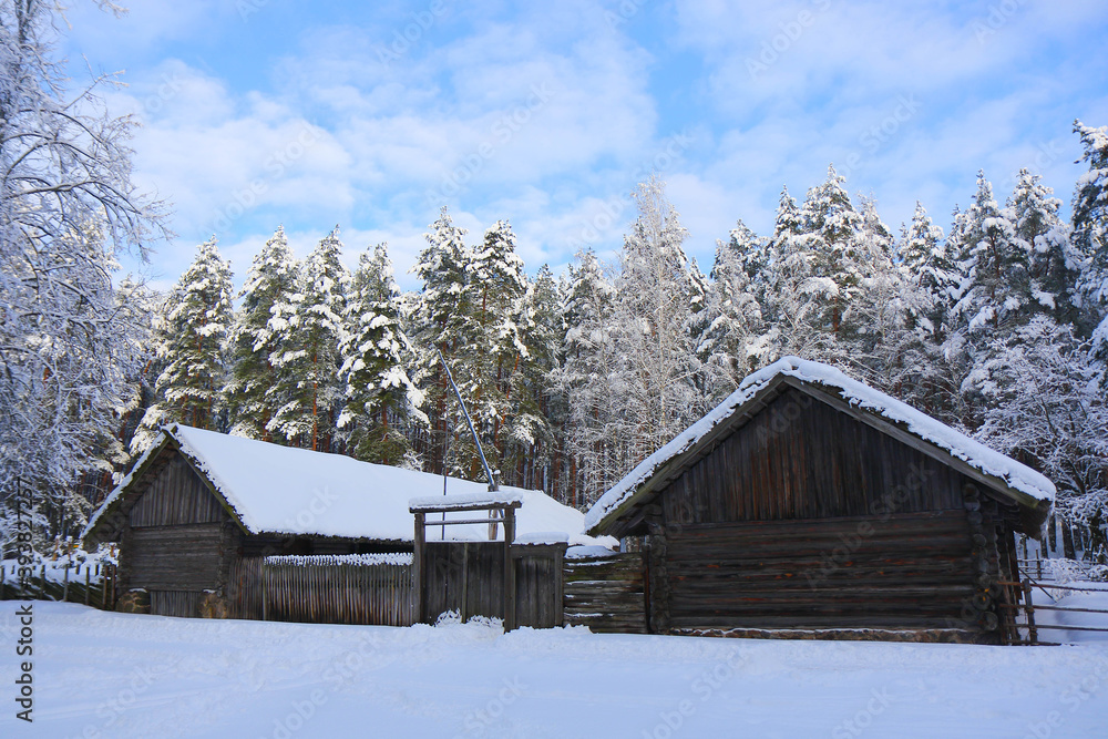 
Winter landscape. An old wooden houses and trees around are covered with snow.