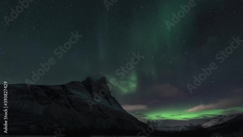 Auroras behind a sharp mountain peak, pan left 4 photo