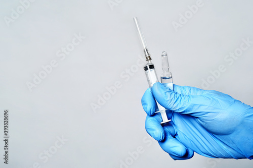 syringe and virus vaccine in hand close-up.