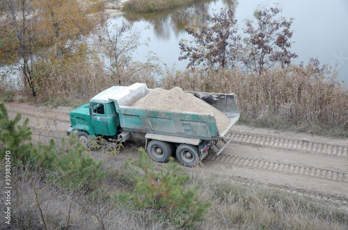 Dump truck transports sand and other minerals in the mining quarry. Heavy industry photo