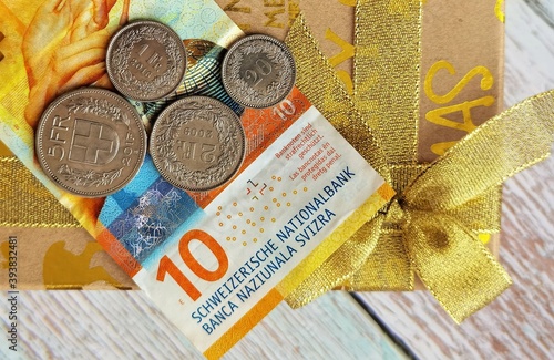 ten Swiss francs and coins on a holiday box with a ribbon photo