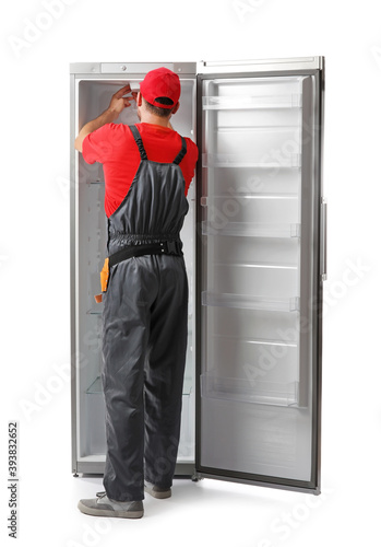 Worker repairing fridge on ...