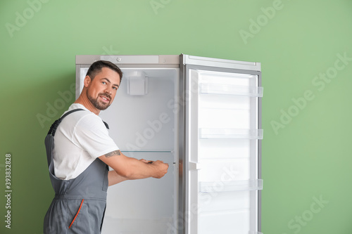 Worker repairing fridge on ...