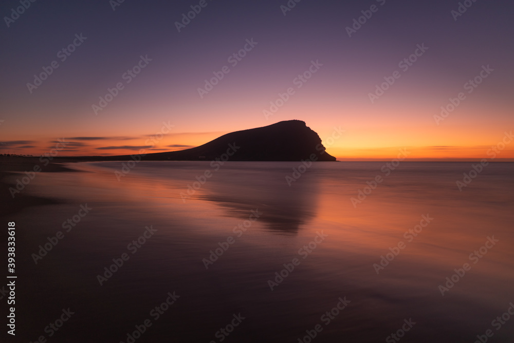 landscape of a sandy beach in a sunset and with reflections in the water