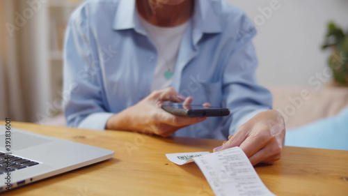 Fotografi Woman using smartphone and scanning qr code paying bills online