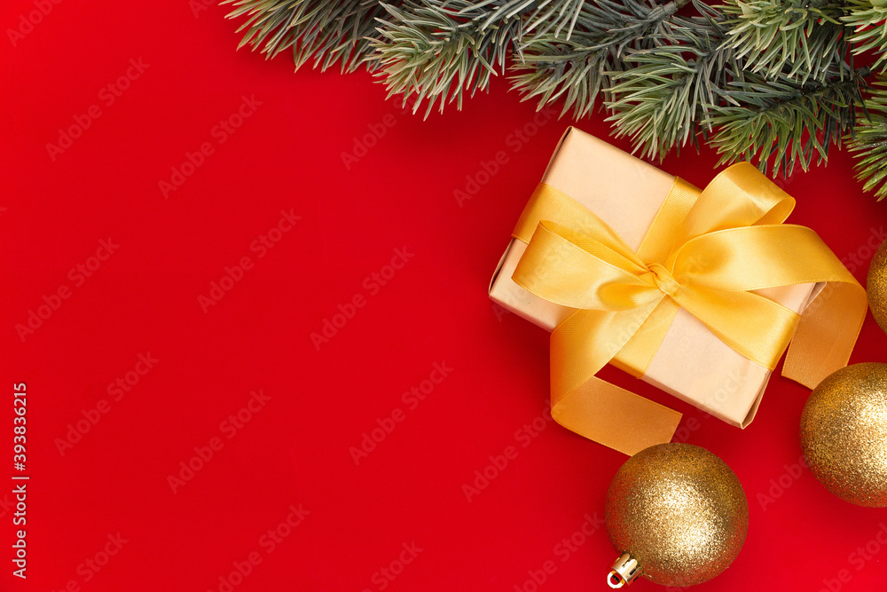 Golden Christmas balls decoration and fir branch on a red background with copy space. New Year composition. Flat lay, top view. Minimalistic style. Golden Christmas balls decoration and fir branch on a red background with copy space. New Year composition. Flat lay, top view. Minimalistic style.