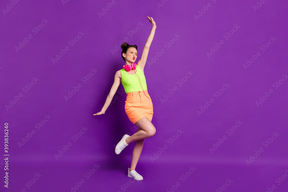Full length body size view of pretty slim funky cheerful girl listening bass having fun dancing isolated on bright violet color background Full length body size view of pretty slim funky cheerful girl listening bass having fun dancing isolated on bright violet color background
