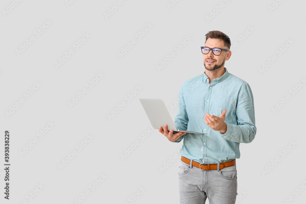 Male psychologist with laptop on light background Male psychologist with laptop on light background