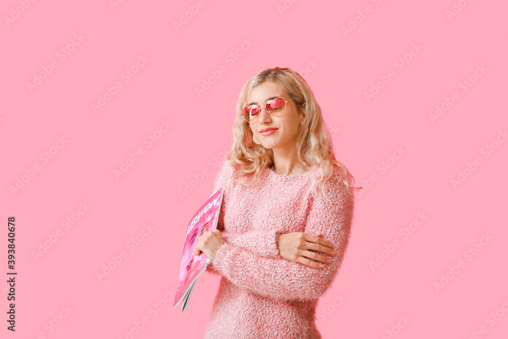 Beautiful young woman in warm clothes and with magazine on color background Beautiful young woman in warm clothes and with magazine on color background