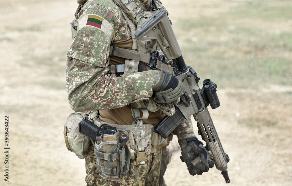 Fototapeta premium Soldier with assault rifle and flag of Lithuania on military uniform. Collage.