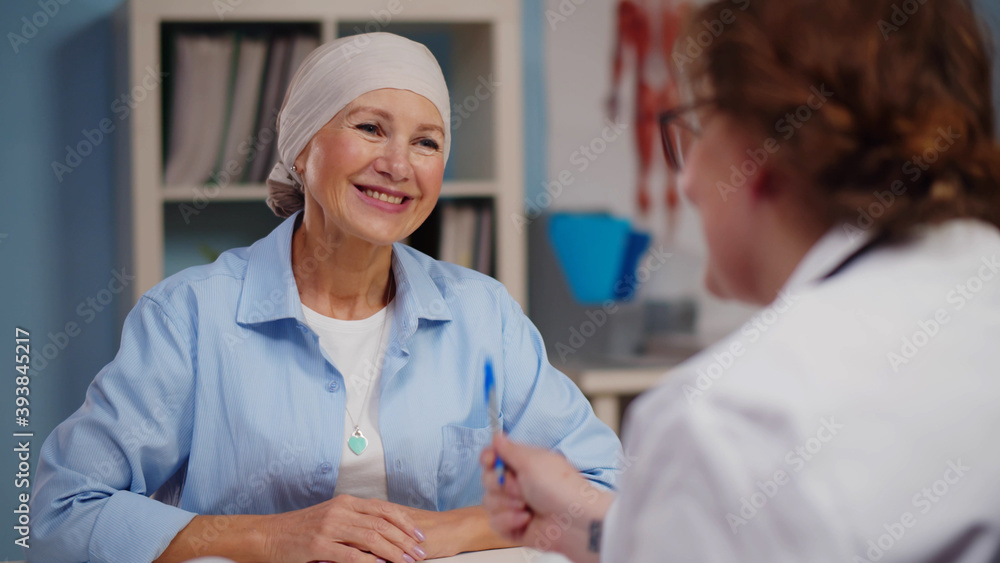 Obraz premium Mature woman with cancer visiting doctor in hospital listening about recovery