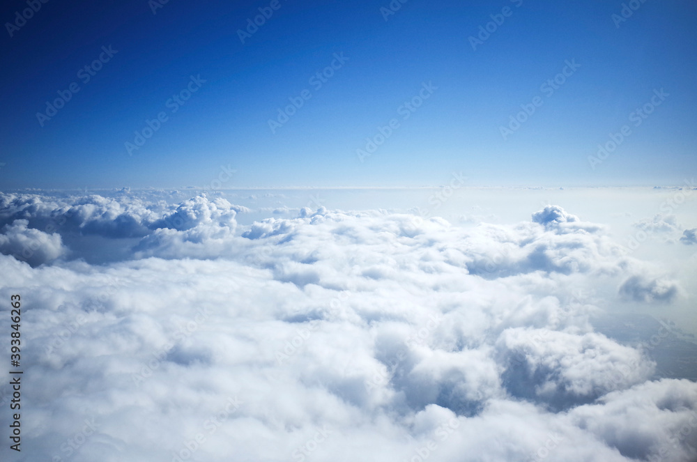 비행기 창문을 통해서 본 하얀 구름이 떠 있는 파란 하늘