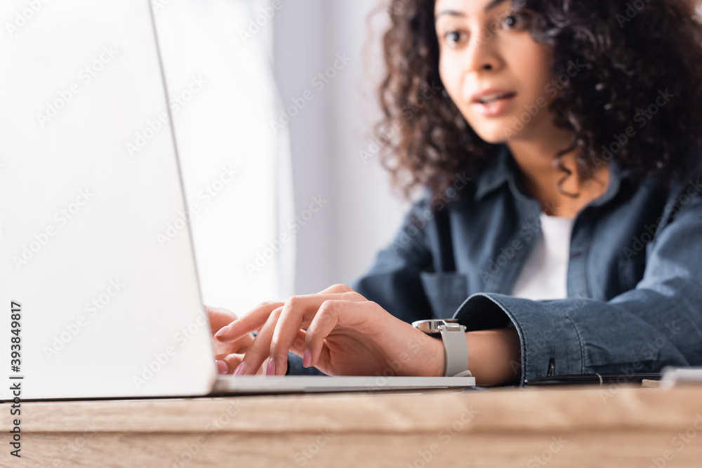 laptop near curly freelancer working from home on blurred background laptop near curly freelancer working from home on blurred background