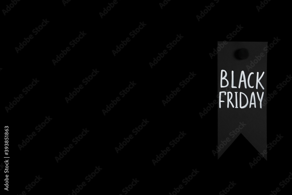 Tag with phrase Black Friday on dark background, space for text
